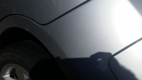 2001 Ford Crown Victoria - Close-up of a silver car's rear fender and tire, showing minor surface damage.