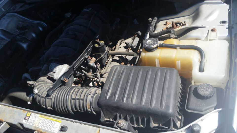 Engine bay of a Dodge with intake, air box and coolant reservoir