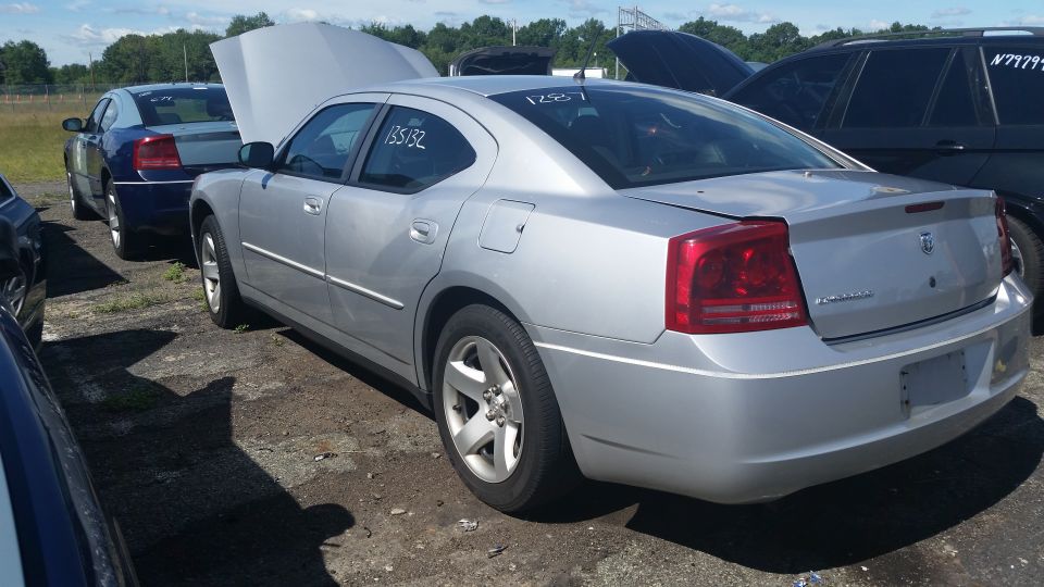 Rear side view of a silver Dodge Charger with hood raised