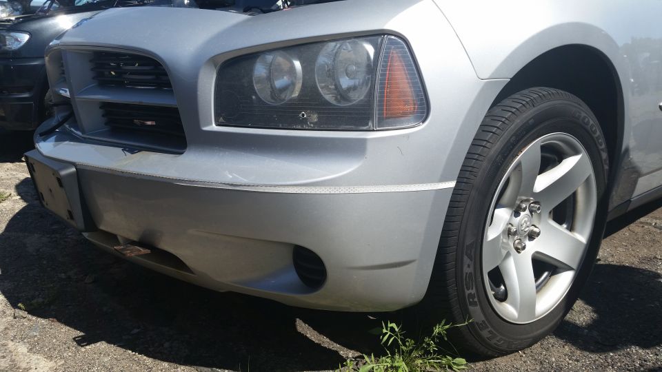 Front corner of a silver Dodge Charger showing headlight and wheel
