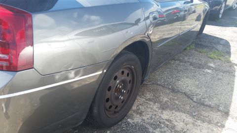 2001 Ford Crown Victoria - Photo of a car rear quarter panel and wheel, not a technical document.