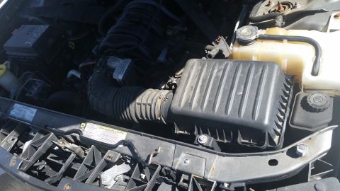 2001 Ford Crown Victoria - Photograph of a vehicle engine bay showing the air filter housing and coolant reservoir, not a technical document.