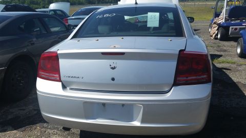 2001 Ford Crown Victoria - Photograph of the rear of a silver Dodge Charger at a salvage auction with grease-pencil lot markings, not a technical document.