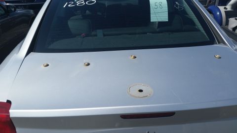 2001 Ford Crown Victoria - Photograph of a silver Charger trunk lid with auction grease-pencil notes on the rear glass, not a technical document.
