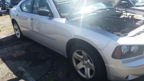 2001 Ford Crown Victoria - Photograph of a silver Dodge Charger front quarter with the hood raised at auction, not a technical document.
