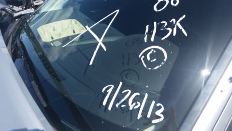 2001 Ford Crown Victoria - Photograph of a windshield with grease-pencil auction markings including a date and lot number, not a technical document.