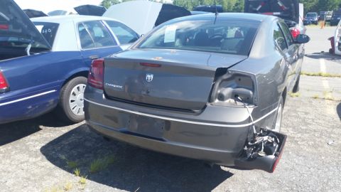 2001 Ford Crown Victoria - Photograph of the damaged rear quarter of a gray Dodge Charger at a salvage yard, not a technical document.