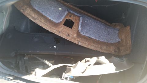 2001 Ford Crown Victoria - Photograph of an open vehicle trunk showing a rusty package tray and interior trim, not a technical document.