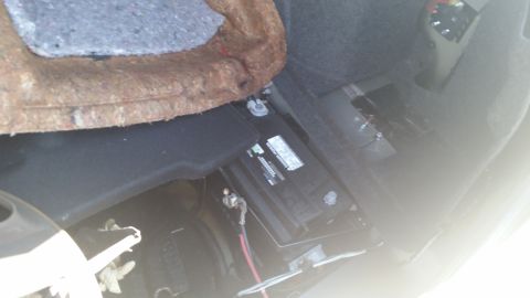 2001 Ford Crown Victoria - Photograph of a vehicle battery mounted in a trunk compartment, not a technical document.