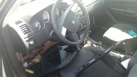 2001 Ford Crown Victoria - Photograph of a vehicle interior with steering wheel, gauge cluster, and disassembled dashboard, not a technical document.