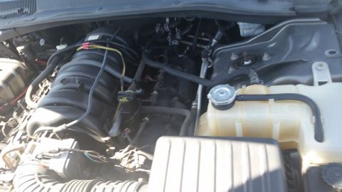 2001 Ford Crown Victoria - Photo of a Dodge Charger engine bay with intake manifold, wiring, and coolant overflow reservoir.