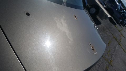 2001 Ford Crown Victoria - Photo of a silver vehicle hood panel surface showing trim mounting holes.
