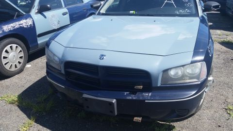 2001 Ford Crown Victoria - Photo of the front of a two-tone blue Dodge Charger with grille and headlights in a salvage yard.