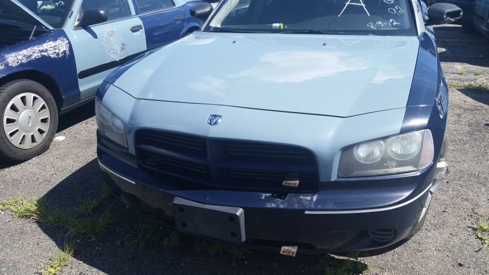 Front end of a two-tone blue Dodge Charger in a salvage lot