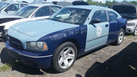 2001 Ford Crown Victoria - Photo of the front fender of a two-tone blue Dodge Charger with grease-pencil codes in a salvage lot.