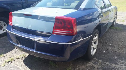 2001 Ford Crown Victoria - Photo of the rear of a two-tone blue Dodge Charger showing trunk and taillights in a salvage lot.