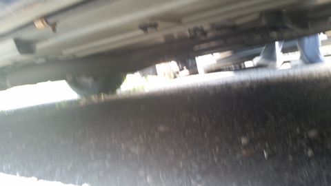 2001 Ford Crown Victoria - Blurry photo of the underside of a vehicle showing floor pan and suspension components.