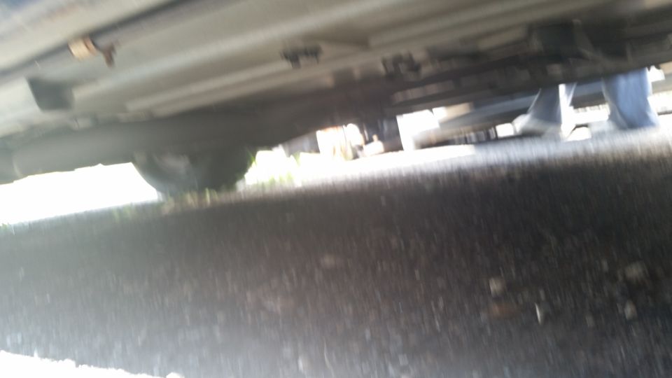 Blurry underside view of a vehicle frame and floor