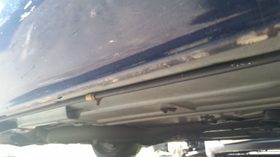 Underside rocker and fuel line of a dark blue vehicle