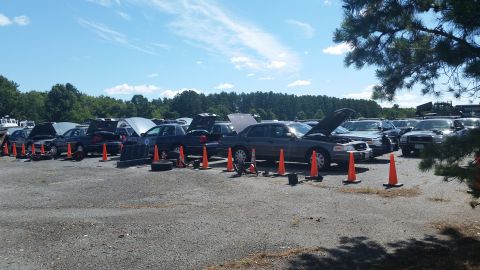 2001 Ford Crown Victoria - Photo of vehicles with open hoods and traffic cones in an outdoor auction lot, not a document.