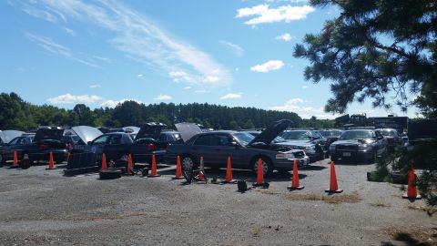 2001 Ford Crown Victoria - Photo of cars with raised hoods and traffic cones in an outdoor lot, not a document.