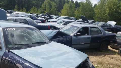 2001 Ford Crown Victoria - Photo of damaged vehicles marked with stock numbers in a salvage yard, not a document.
