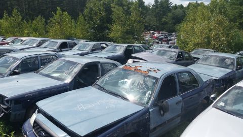 2001 Ford Crown Victoria - Photo of crowded salvage vehicles marked with numbers in a yard, not a document.