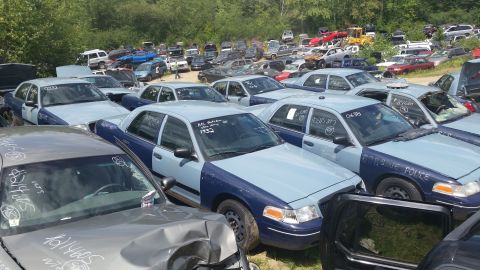 2001 Ford Crown Victoria - Photo of police sedans crowded in a salvage yard, not a document.