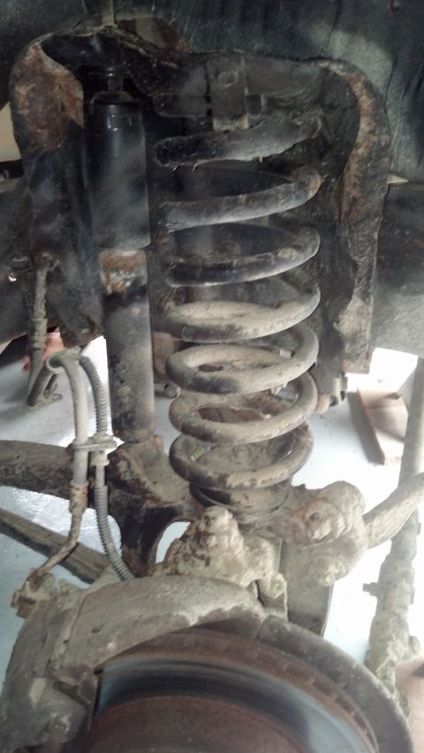 1996 Ford Bronco - This is a close-up view of the front suspension of a 1996 Ford Bronco. The image shows the shock absorber, coil spring, and part of the bra…