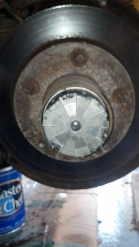 1996 Ford Bronco - A close-up view of a vehicle's brake rotor and hub assembly. The brake rotor is worn and rusty, and the hub has a cooling fan visible insid…