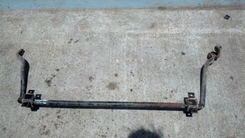 1996 Ford Bronco - A rusty sway bar assembly, likely from a 1996 Ford Bronco, is laid out on a concrete surface. The part features a central bar with two angl…