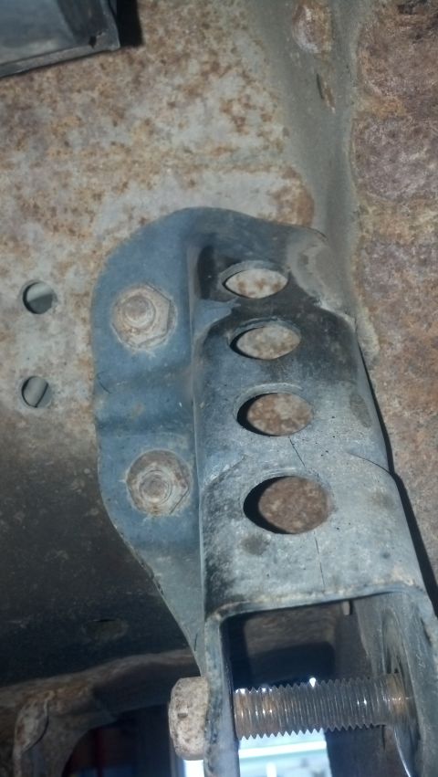 1996 Ford Bronco - This image shows a close-up of rusty metal components and bolts, likely part of a vehicle's undercarriage or suspension system. The focus i…