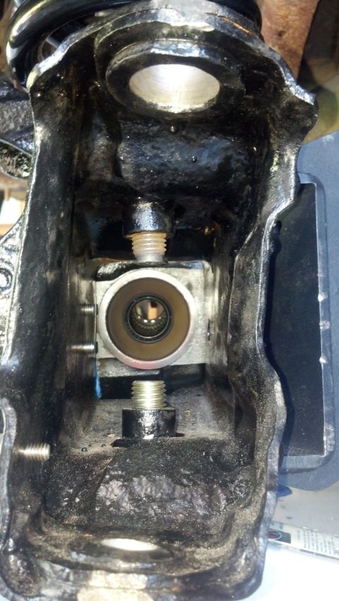 1996 Ford Bronco - A close-up view inside a heavily greased, black metal housing, revealing a cylindrical metal component with splines visible through its ope…