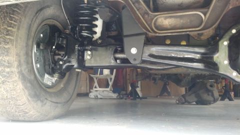 1996 Ford Bronco - The underside of a vehicle shows the suspension components, including the coil spring and shock absorber, attached to the frame and axle. A…