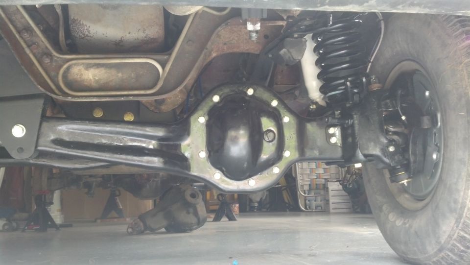 Underside view of a vehicle's rear axle and suspension system.