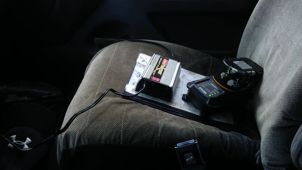PowerBright inverter and Ryobi charger on a car seat.