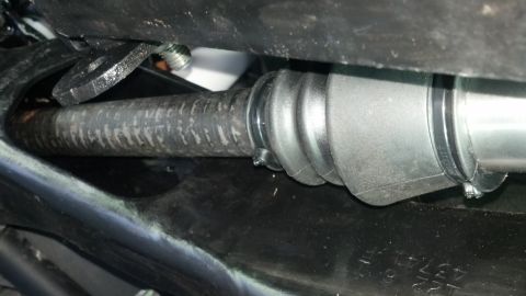 1996 Ford Bronco - A close-up view shows a rubber bellows boot secured by metal clamps around a ribbed hose, likely part of a vehicle's steering or suspension…