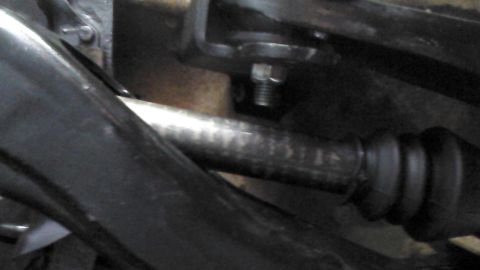 1996 Ford Bronco - A close-up view shows a metal shaft with a ribbed rubber boot attached to its end, likely part of a vehicle's suspension or drivetrain syst…