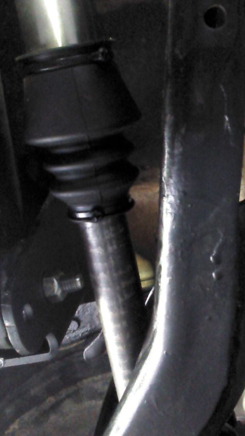 1996 Ford Bronco - A close-up view shows a black rubber boot with accordion folds, secured by a metal clamp, covering a metal shaft. The shaft is attached to…
