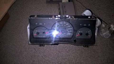2004 Ford Crown Victoria - A close-up view of a car's instrument cluster, featuring a speedometer, tachometer, fuel gauge, and temperature gauge. The cluster is illum…