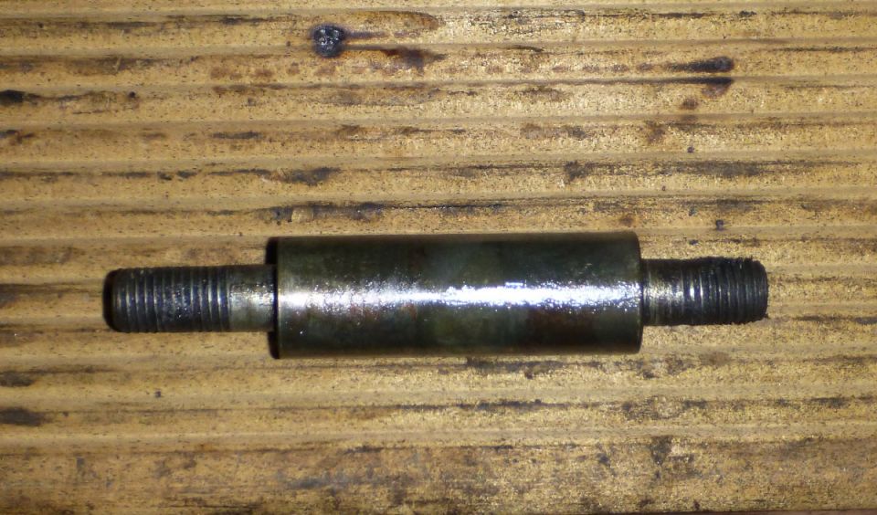 Metal part with threaded ends on wooden surface