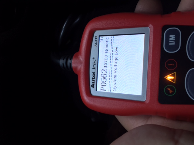 Red AutoLink AL319 diagnostic scanner showing P0562 System Voltage Low error code