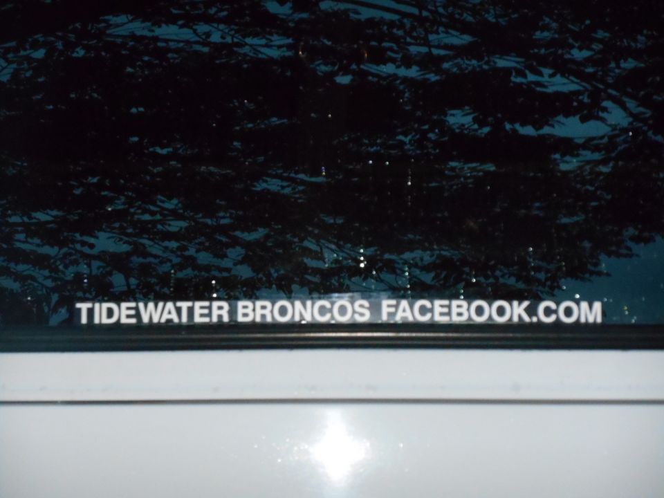 White vehicle with text "TIDEWATER BRONCOS FACEBOOK.COM" on the window.