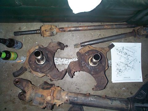 1981 Ford Bronco - Dana 44 front axle parts, including knuckles and driveshafts, laid out with a technical diagram.