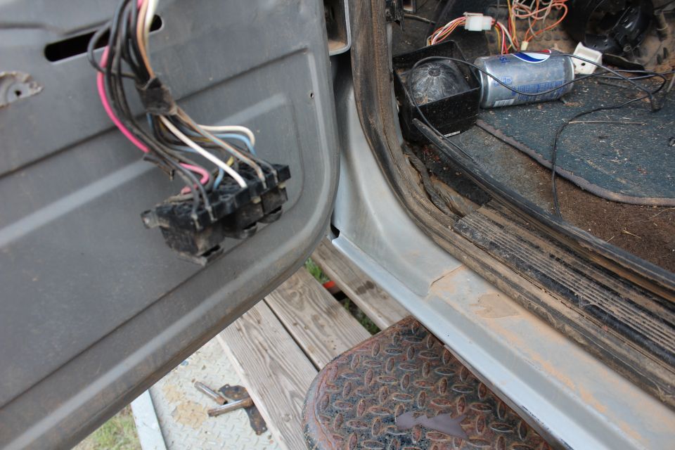 Close-up of vehicle door interior with wires and electrical connector.
