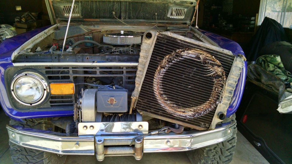 Purple SUV with hood open, showing a damaged radiator and a front-mounted winch.