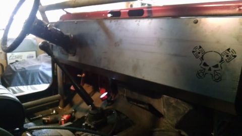 1985 Jeep CJ7 - The interior of a modified Jeep CJ7 shows a custom metal dashboard with a skull and pistons decal. Visible parts include the steering wheel…