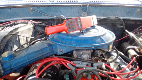 1978 Ford Bronco - A red and black Snap-on timing light rests on top of a blue air cleaner assembly in the engine bay of a vehicle. The engine appears to be a…