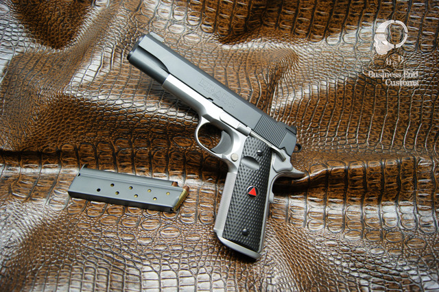 Handgun and magazine on textured brown surface with custom shop watermark