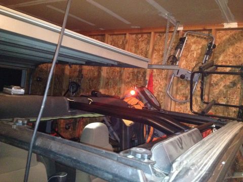 2005 Jeep Wrangler - The interior of a Jeep Wrangler is shown with the top removed, revealing the roll cage and seats. A bike rack is mounted on the wall behind…
